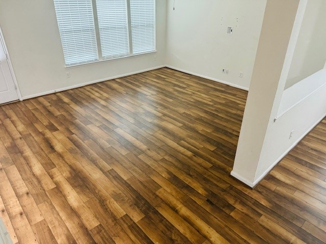 unfurnished room with dark hardwood / wood-style flooring