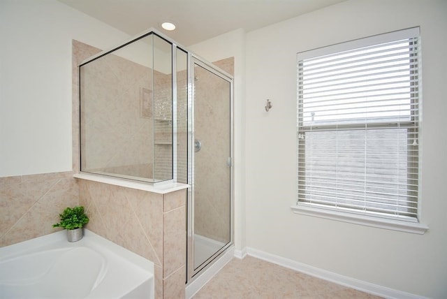 bathroom with tile patterned flooring and shower with separate bathtub