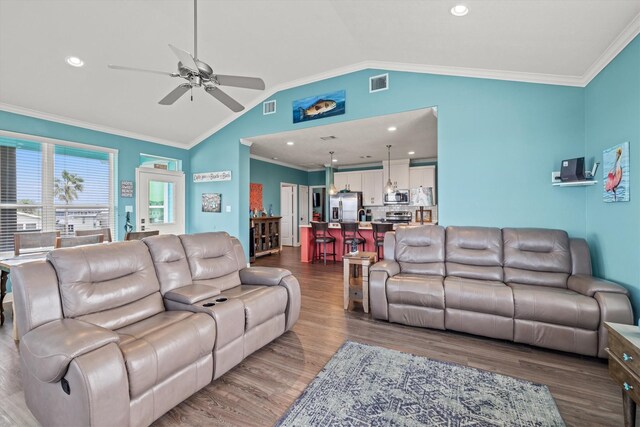 living room featuring vaulted ceiling, ceiling fan, dark hardwood / wood-style floors, and crown molding