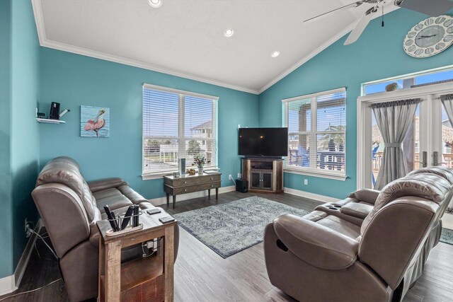 living room with hardwood / wood-style flooring, lofted ceiling, plenty of natural light, and crown molding