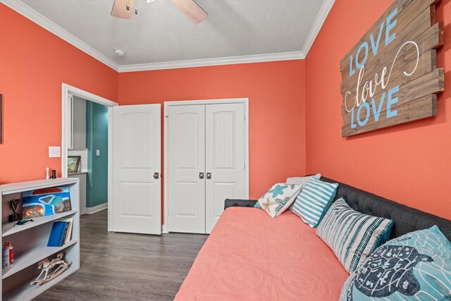 bedroom with ornamental molding, a closet, ceiling fan, and dark hardwood / wood-style flooring