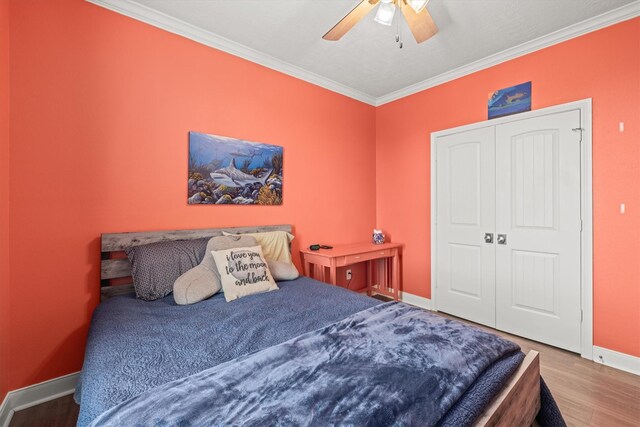 bedroom with ornamental molding, wood-type flooring, a closet, and ceiling fan