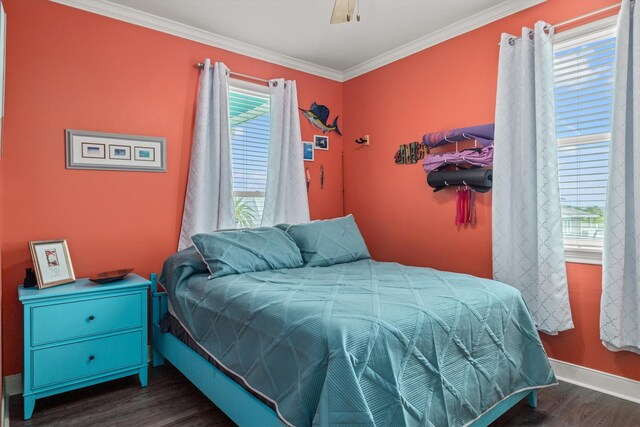 bedroom featuring crown molding, dark wood-type flooring, and ceiling fan