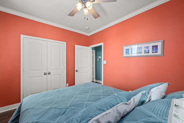 bedroom with ornamental molding, hardwood / wood-style floors, ceiling fan, and a closet