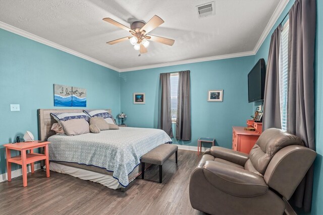 bedroom featuring a textured ceiling, ceiling fan, hardwood / wood-style floors, and crown molding