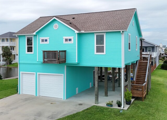 rear view of property with a lawn, a carport, and a garage