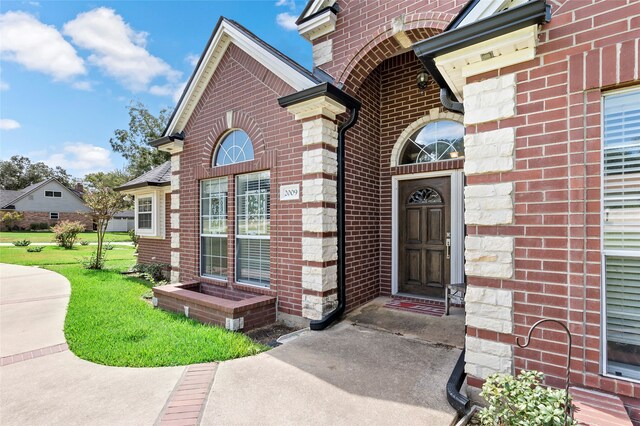 entrance to property featuring a lawn