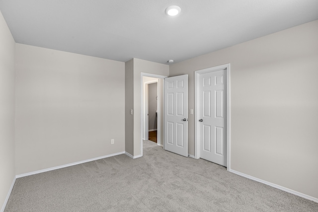 unfurnished bedroom featuring light colored carpet and a closet