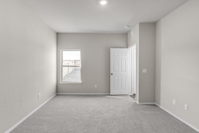 spare room featuring light carpet