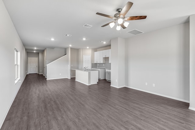 unfurnished living room featuring ceiling fan and dark hardwood / wood-style floors