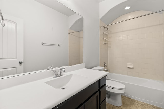 full bathroom with tile patterned flooring, toilet, tiled shower / bath combo, and vanity