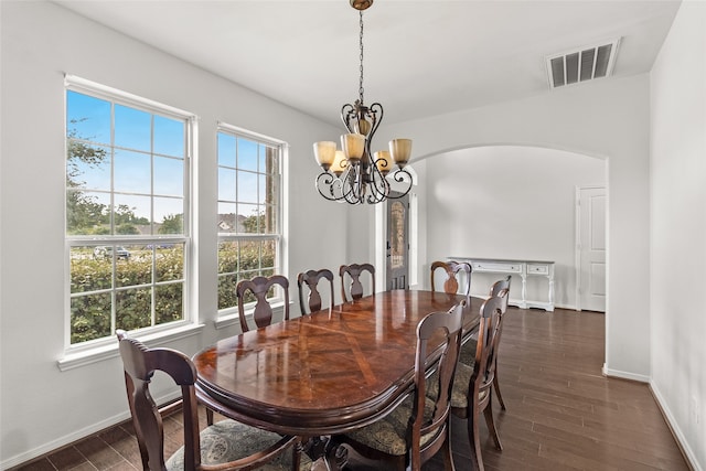 dining area with a wealth of natural light, dark hardwood / wood-style flooring, and a chandelier