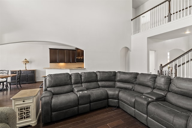 living room featuring a high ceiling and dark hardwood / wood-style flooring