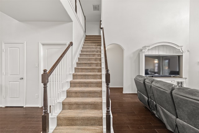 stairway featuring a high ceiling and hardwood / wood-style flooring