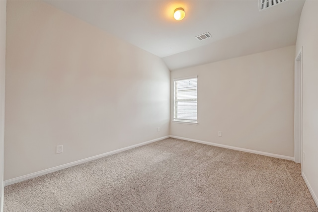 empty room with lofted ceiling and light carpet