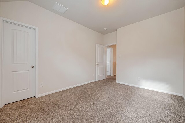 spare room featuring lofted ceiling and carpet floors