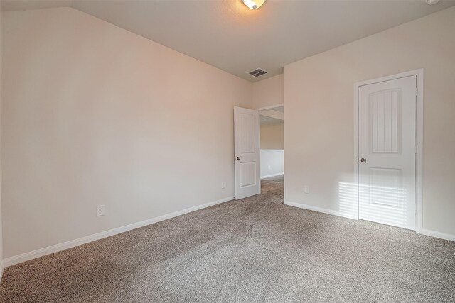 unfurnished bedroom featuring lofted ceiling, carpet, and a closet