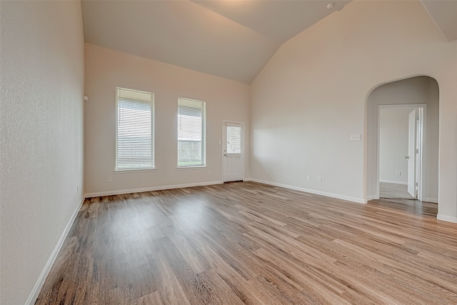 empty room with lofted ceiling and light hardwood / wood-style floors