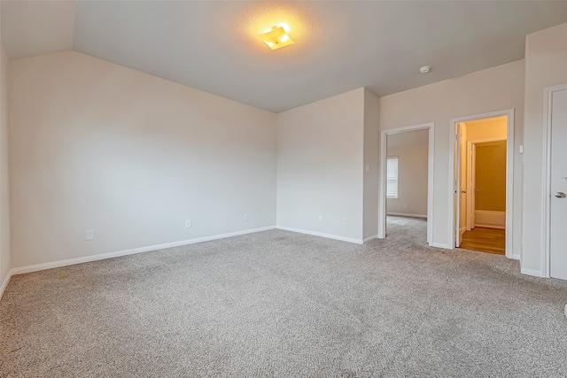 empty room with lofted ceiling and light colored carpet