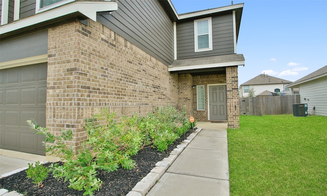 doorway to property with a garage and a yard