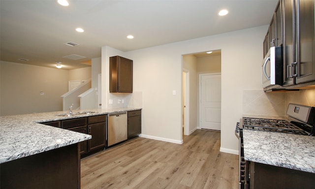 kitchen featuring light stone countertops, stainless steel appliances, light hardwood / wood-style floors, tasteful backsplash, and dark brown cabinetry