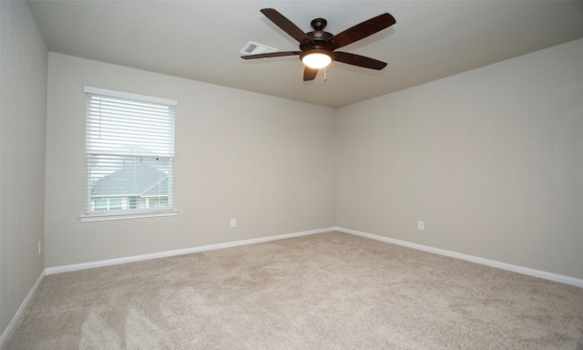 carpeted spare room featuring ceiling fan and a wealth of natural light