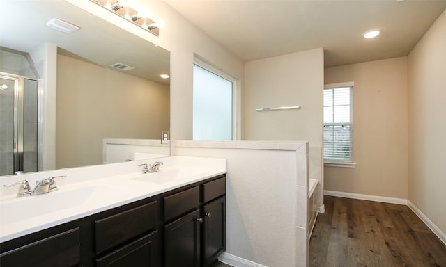 bathroom with hardwood / wood-style floors, shower with separate bathtub, and vanity