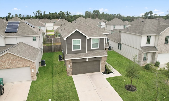 view of front of property with central air condition unit, a garage, a front yard, and solar panels