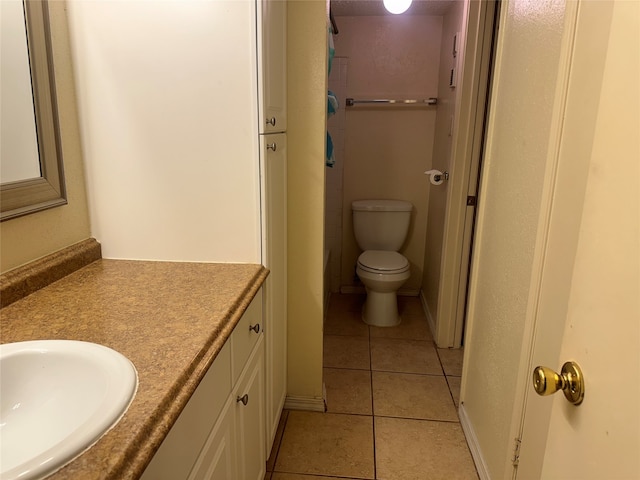 bathroom featuring tile patterned flooring, toilet, and vanity