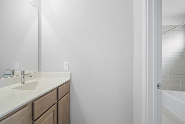 bathroom with vanity and tiled shower / bath combo