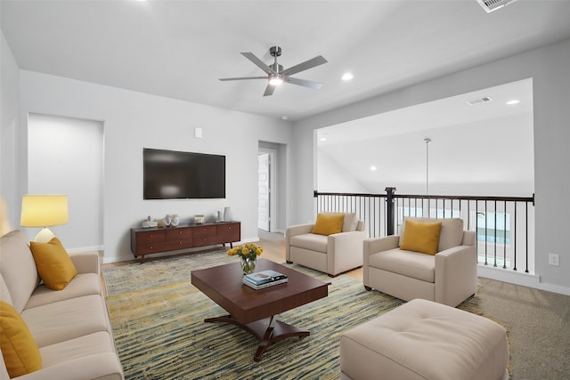 carpeted living room with plenty of natural light, ceiling fan, and vaulted ceiling