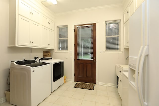 laundry area featuring ornamental molding, cabinets, and washer and dryer