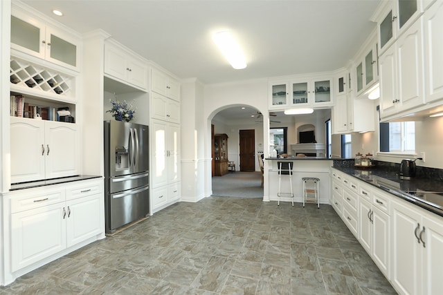 kitchen featuring stainless steel refrigerator with ice dispenser, white cabinetry, and ornamental molding