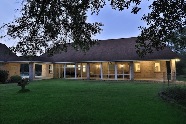 back house at dusk with a yard