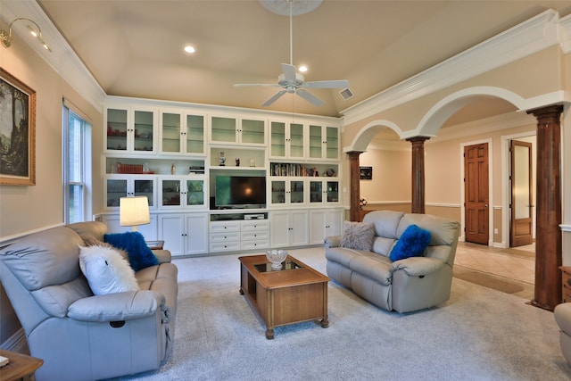 carpeted living room featuring crown molding, built in features, decorative columns, ceiling fan, and a raised ceiling