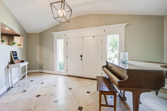 tiled entryway featuring an inviting chandelier and vaulted ceiling