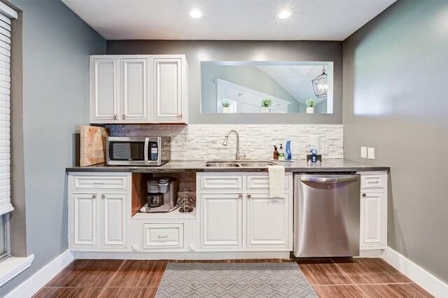 bar with appliances with stainless steel finishes, white cabinetry, backsplash, and sink