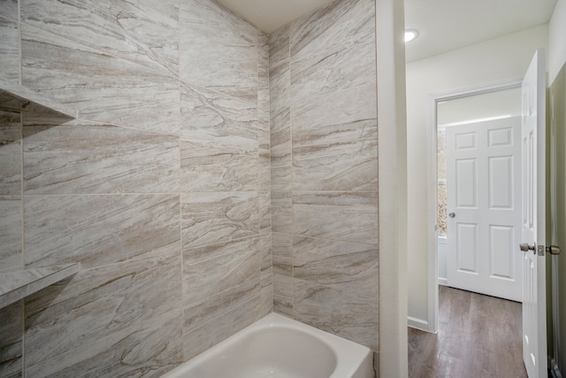 bathroom featuring tiled shower / bath and wood-type flooring