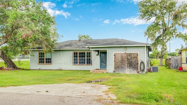 view of front of property with a front yard and central AC unit