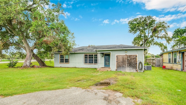 back of property featuring a lawn and central air condition unit