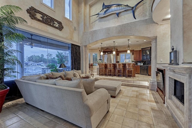 living area with a fireplace, arched walkways, and ornamental molding