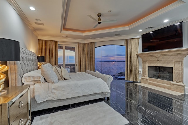 bedroom featuring a raised ceiling, a fireplace, access to outside, ornamental molding, and ceiling fan