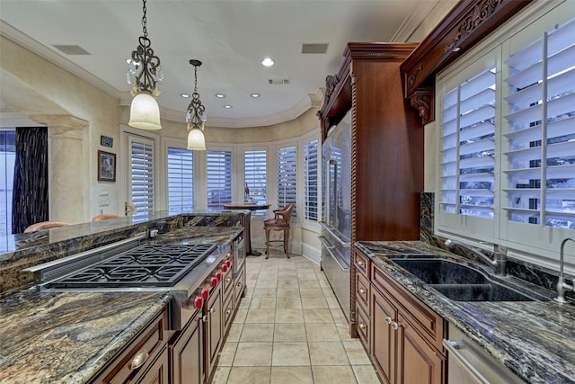 kitchen featuring visible vents, pendant lighting, ornamental molding, a sink, and stainless steel appliances