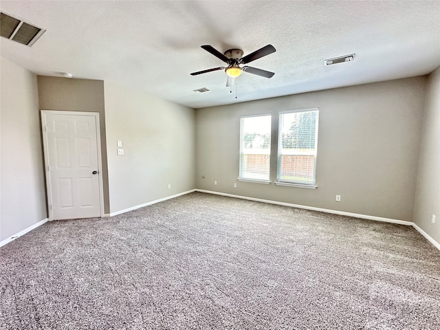 spare room with a textured ceiling, ceiling fan, and carpet