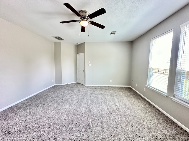 unfurnished room featuring a textured ceiling, carpet, and ceiling fan