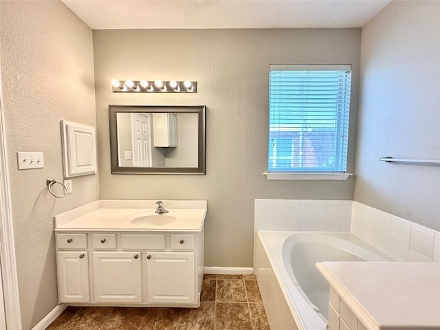 bathroom featuring tile patterned flooring, a bathing tub, and vanity