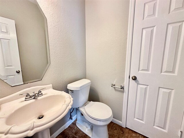 bathroom with tile patterned flooring, toilet, and sink