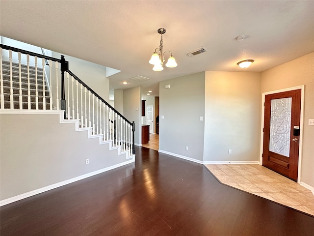 foyer with an inviting chandelier and wood-type flooring