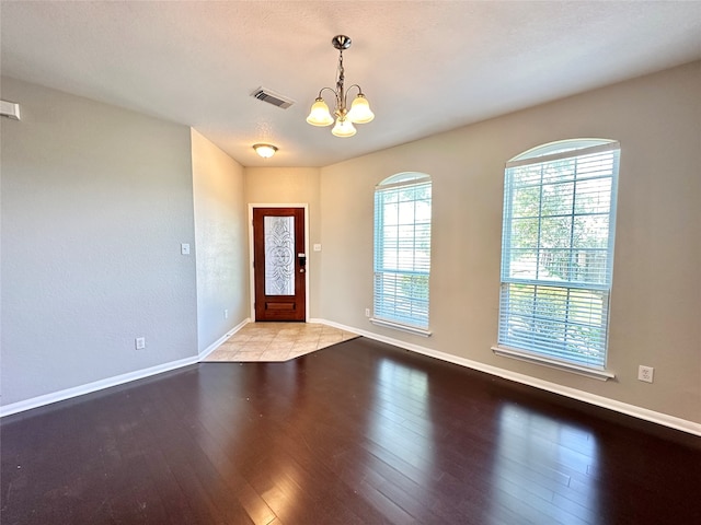 foyer entrance featuring an inviting chandelier and light hardwood / wood-style flooring