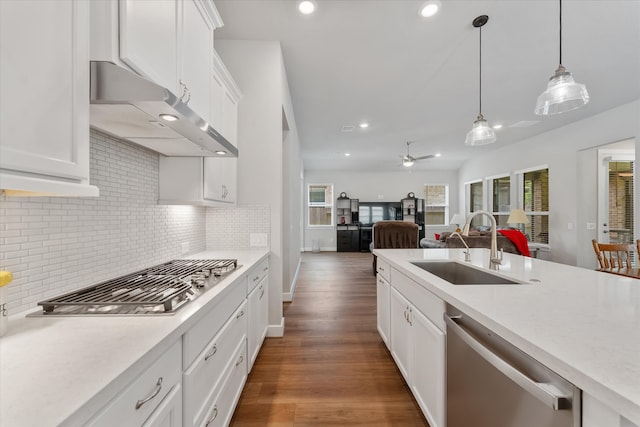 kitchen featuring pendant lighting, stainless steel appliances, sink, ceiling fan, and white cabinets